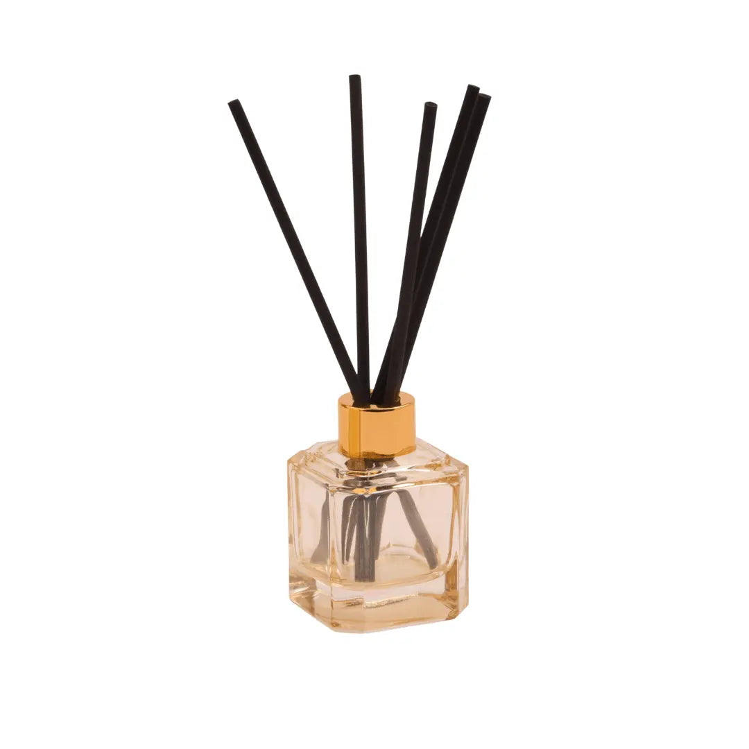 The Botanica Glass Diffuser - Cotton + Teak features a gold cap and black sticks in light liquid, offering an elegant, candle-free scent solution from the Luxurious Botanica Collection, beautifully presented against a white background.