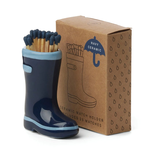 The Wellington Boot Matches - Navy Blue is a ceramic match holder shaped like a navy rain boot, holding safety matches beside a brown box that displays an illustration of the matching boot.