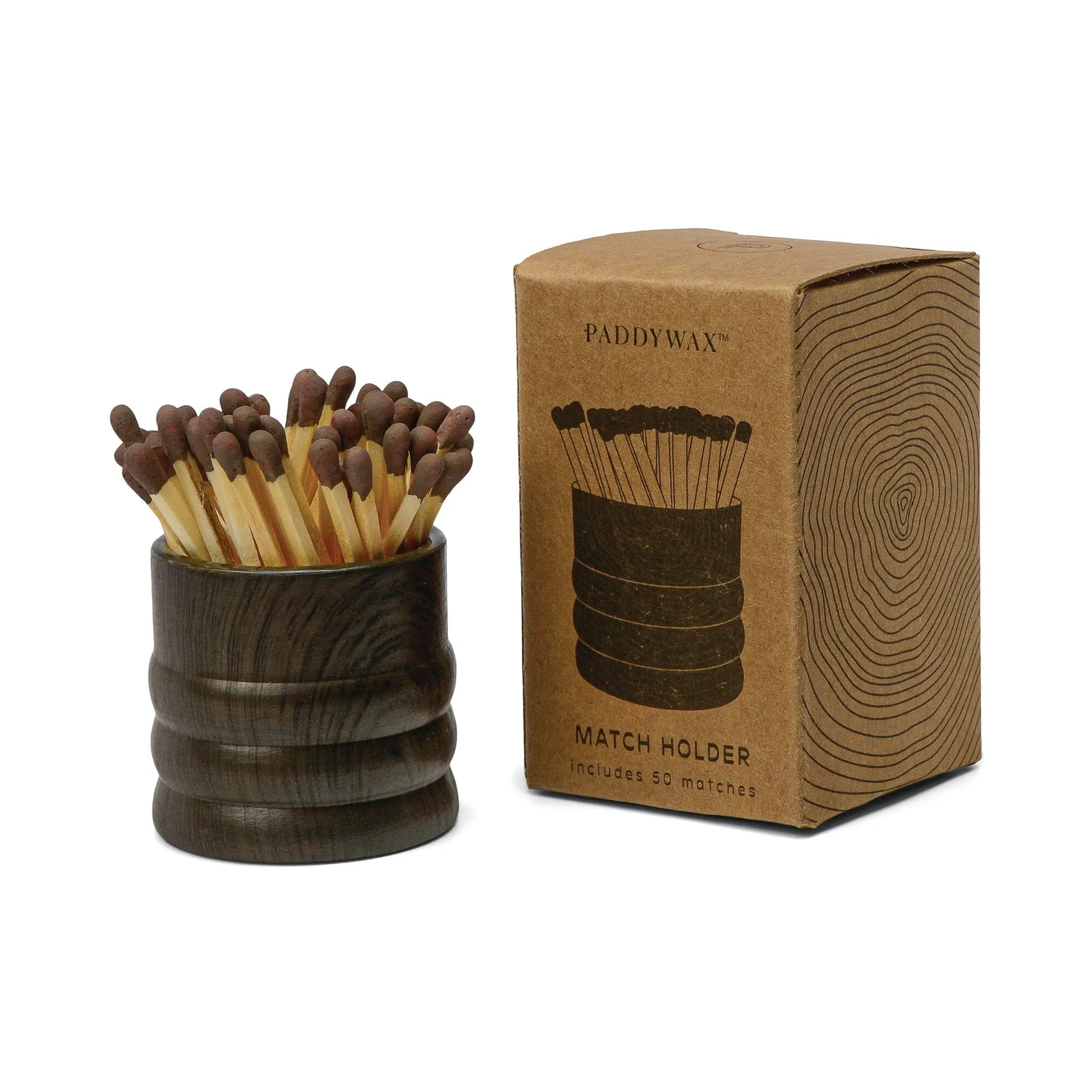 The Dark Brown Ceramic Wood Match Holder, filled with matches, sits beside its brown Paddywax Match Holder box, which displays a tree ring design and product illustration.