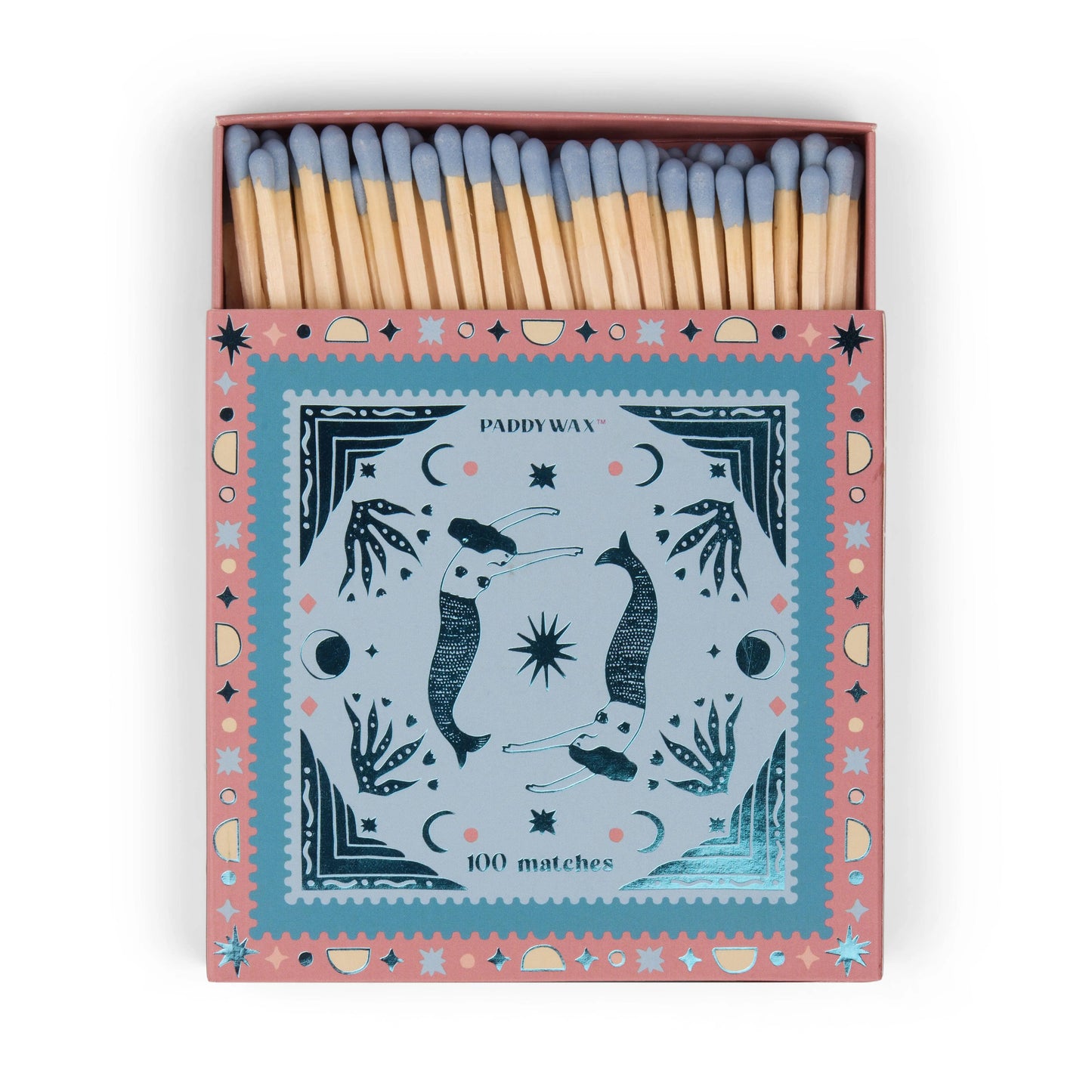 A pink matchbox with a blue decorative lid featuring illustrated mermaids, stars, and plants. The box is open to reveal matches inside—perfect for lighting your favorite Paddywax candle. Product: Jumbo Boxed Matches - Mermaids.