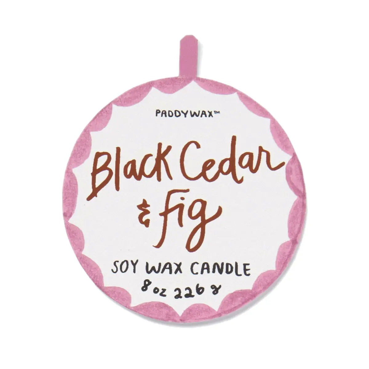 Round label with pink scalloped border reads A Dopo Tiger Candle - Black Cedar & Fig in handwritten-style text, capturing the bold fragrances often found in Mediterranean candles.