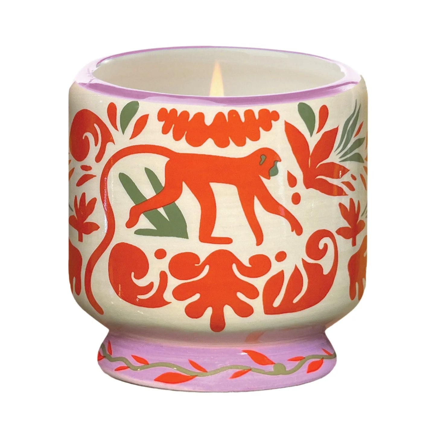 The A Dopo Jungle Candle - Coconut & Amber comes in a decorative ceramic holder with hand-painted folk art designs in red, green, and orange, featuring a charming monkey motif.