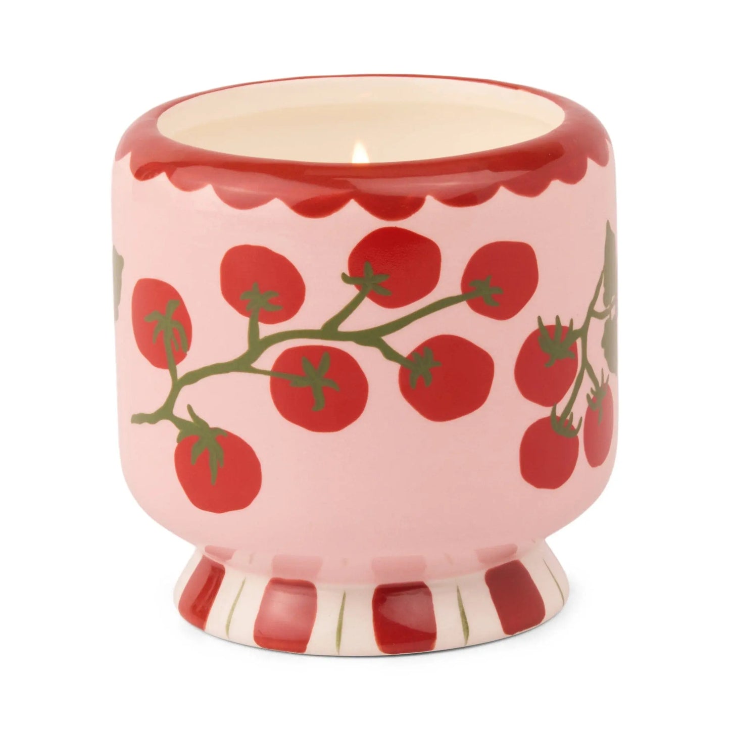 The A Dopo Tomato Vine Candle - Heirloom Tomato features a pink ceramic holder with heirloom tomatoes on green vines and a base accented by bold red and white vertical stripes.