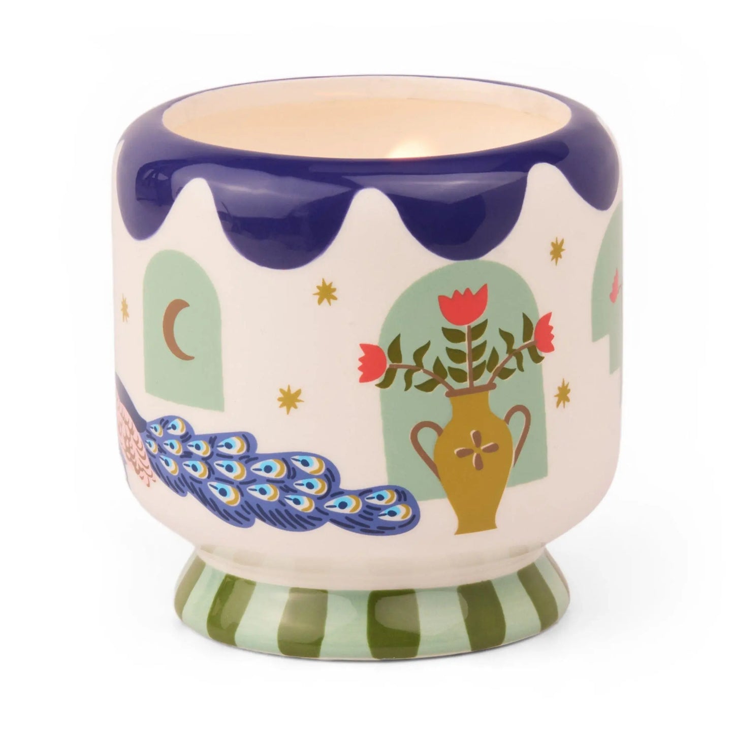 The A Dopo 8 oz Handpainted Peacock Ceramic in Misted Lime features imaginative patterns—vase, flowers, peacock, windows, stars, and a crescent moon. Light a candle inside to release bold fragrances.