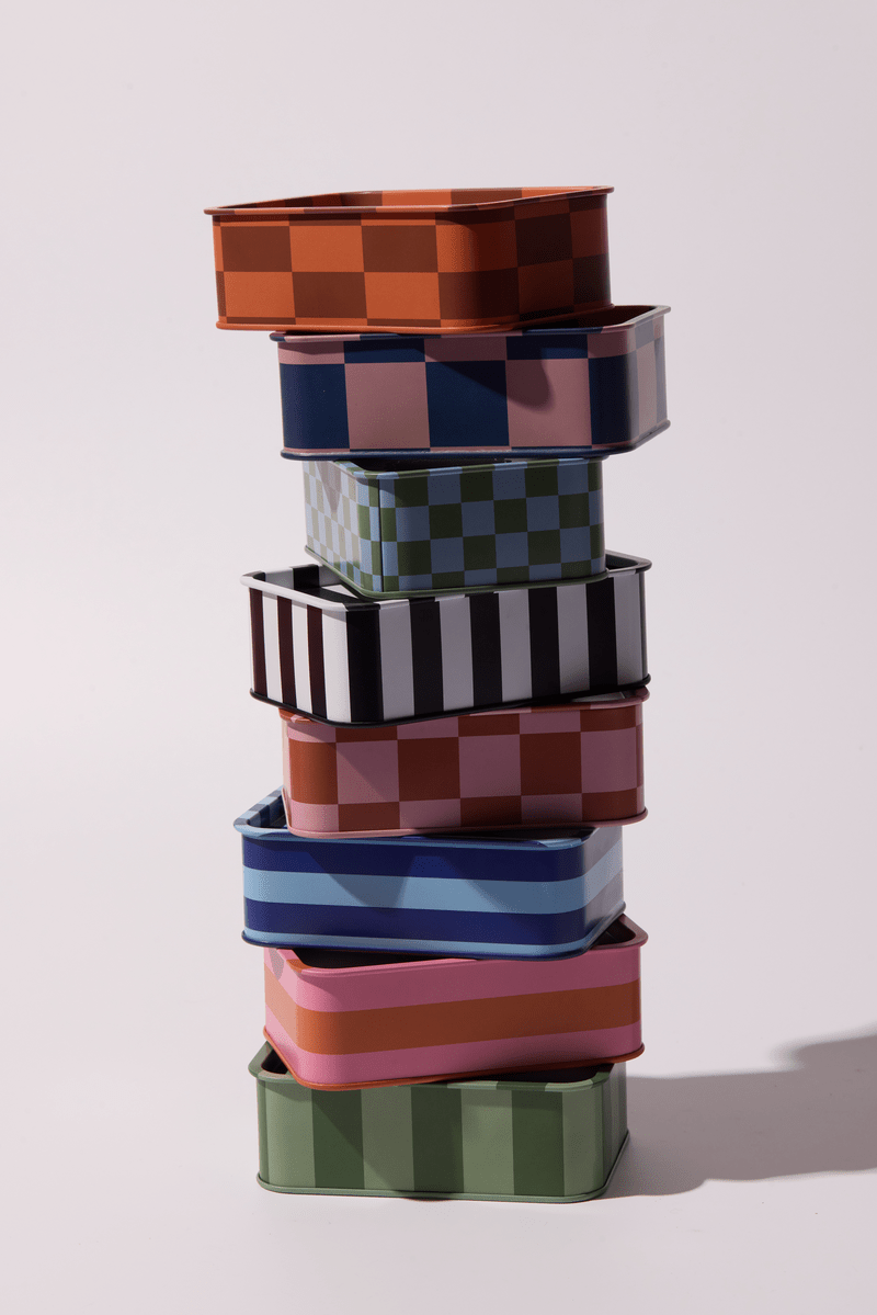 Stack of colorful tin candles on a light background