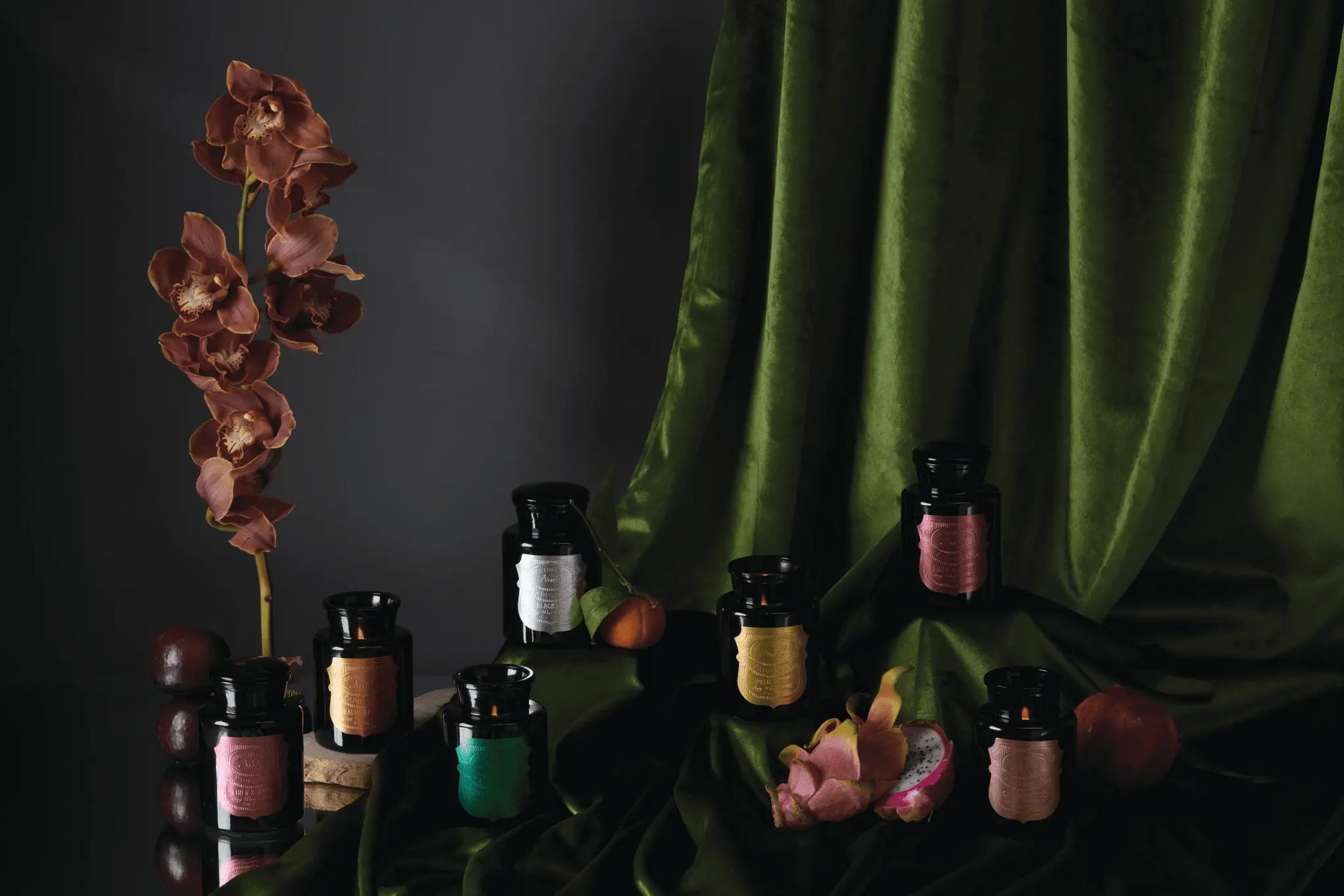 The Apothecary Noir collection on a table with green cloth.