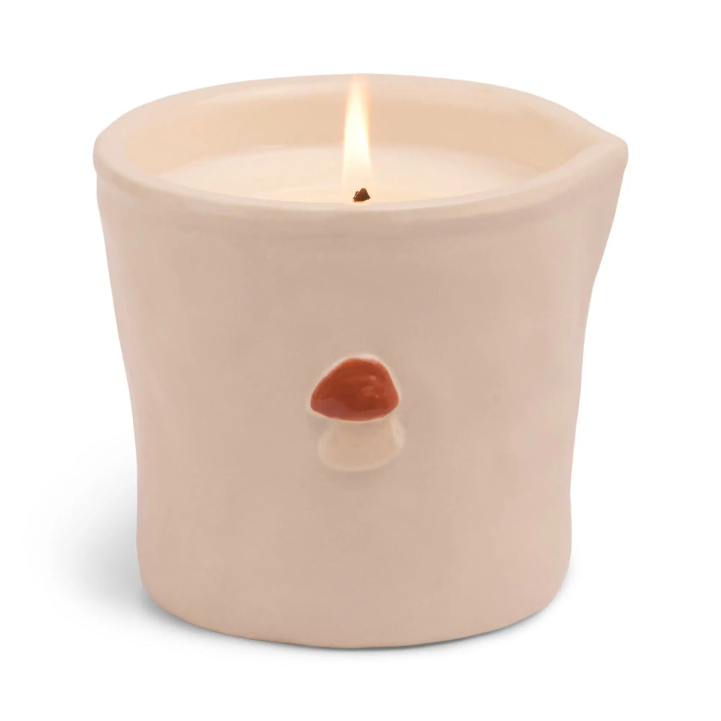 The Bistro Candle - Wild Mushroom features a lit white candle in a cream ceramic holder, adorned with a small red and white mushroom on the front for whimsical charm and aromatic fragrance.