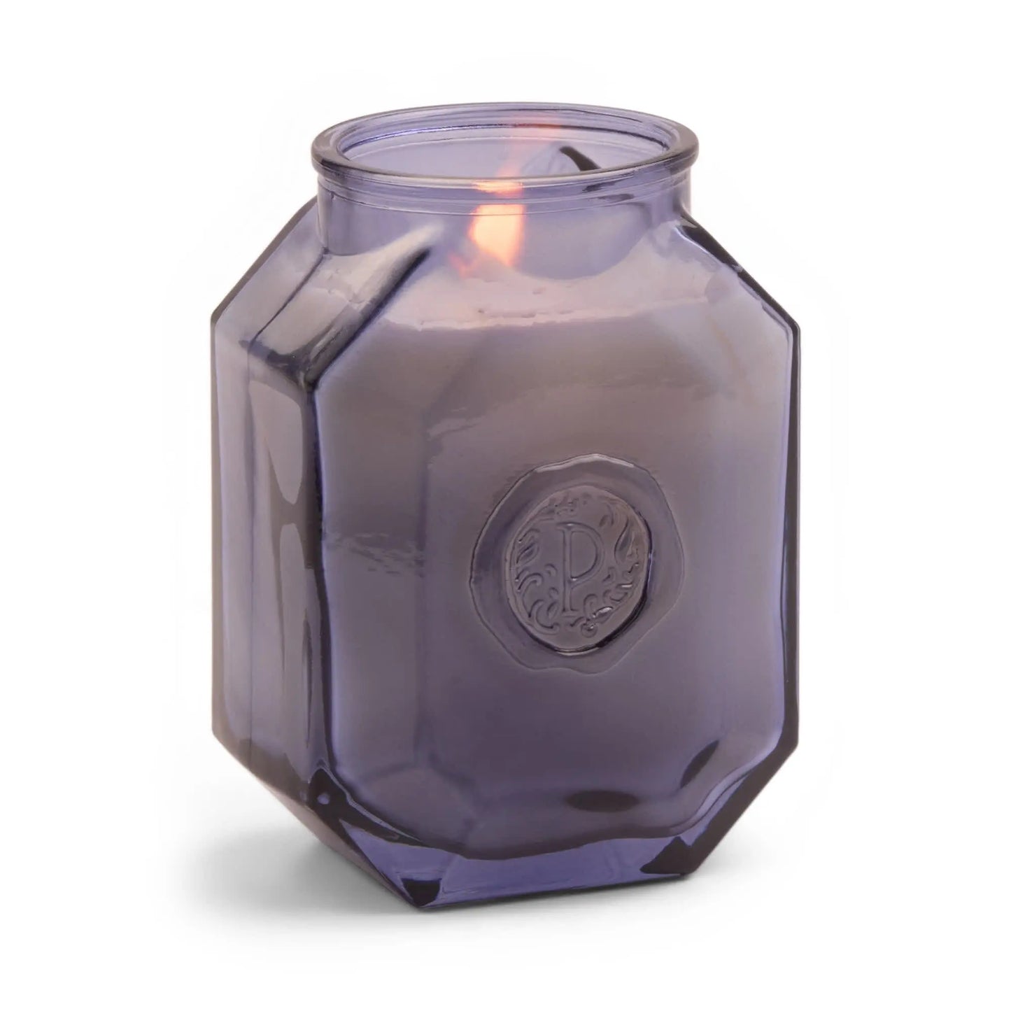 The Botanica Candle - Sea Salt + Amber glows in an elegant hexagonal purple glass vessel with an embossed circular design—perfect for lovers of refined candles and diffusers.