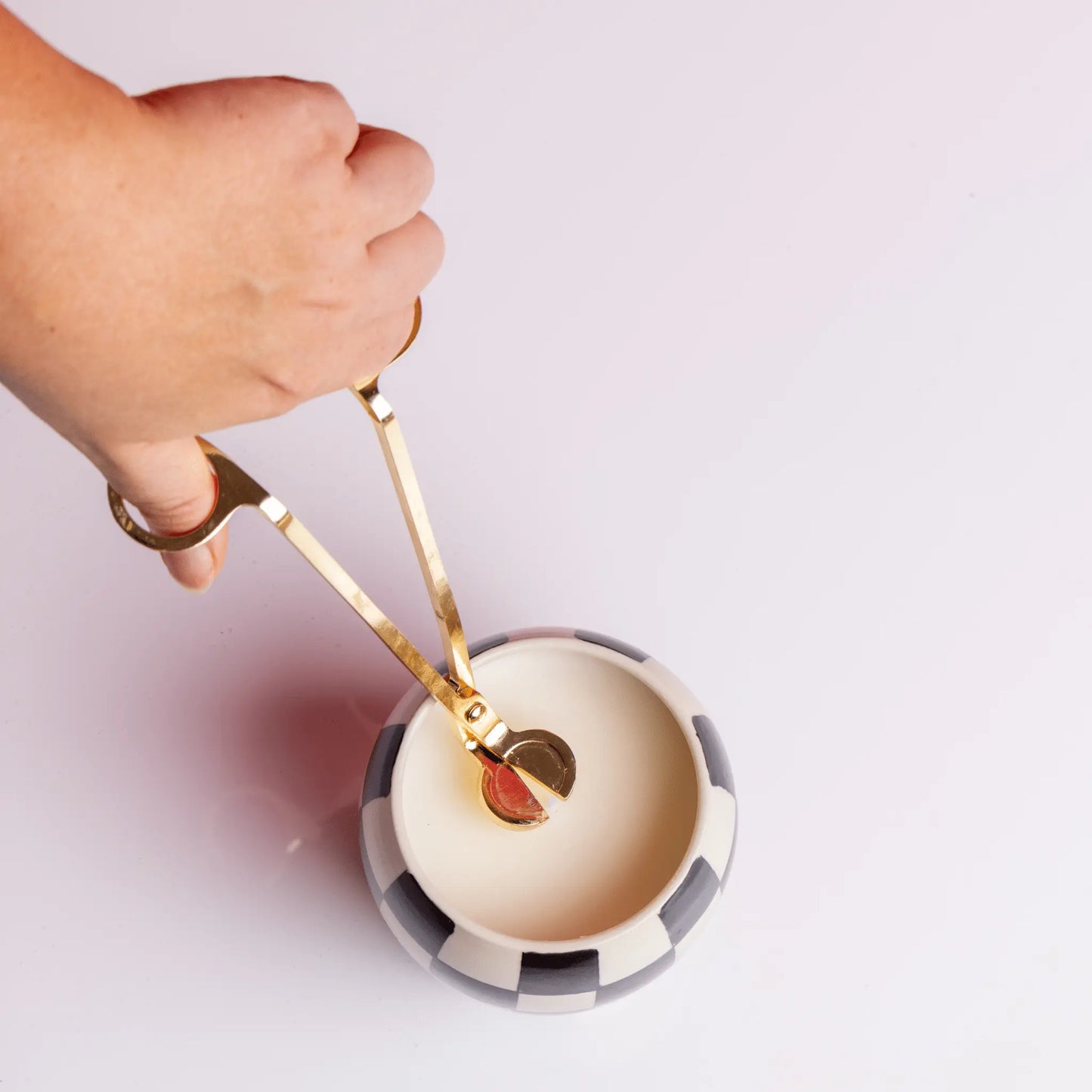 Brass Wick trimmer and candle on white table