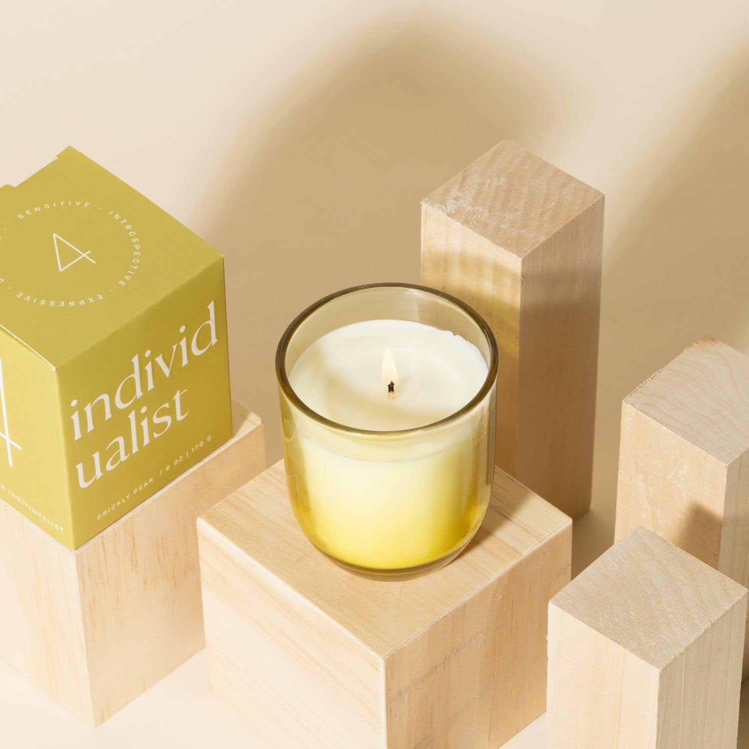 Yellow candle with white soy wax burning with yellow packaging near candle - Enneagram Candle Paddywax for Enneagram 4 the individualist