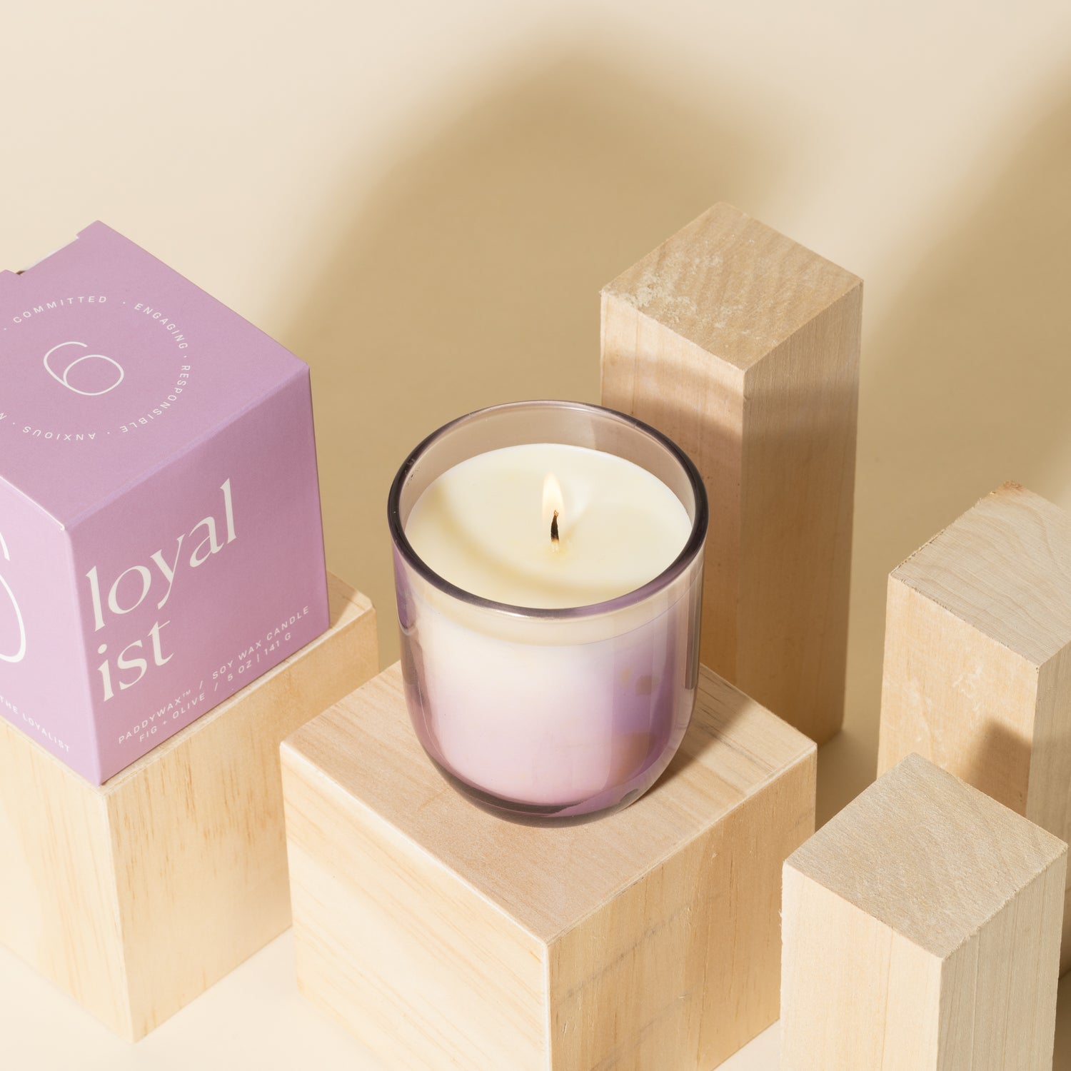 Lilac purple candle with white soy wax burning with lilac purple packaging near candle - Enneagram Candle Paddywax for Enneagram 6 the loyalist