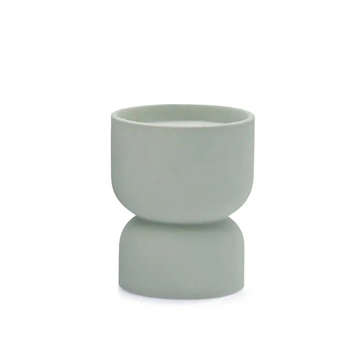 The Form 6oz. Mint Matte Hourglass Ceramic Ocean Rose & Bay cup features a light green matte finish, a double-bowl hourglass design, and symmetrical shape—shown here as a unique vessel on a white background.