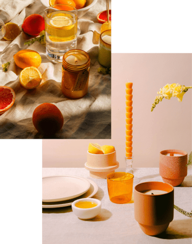 A table with citrus fruits, candles, glassware, and a water glass; below, a set table with orange glassware, ceramics, and a yellow flower in a vase.