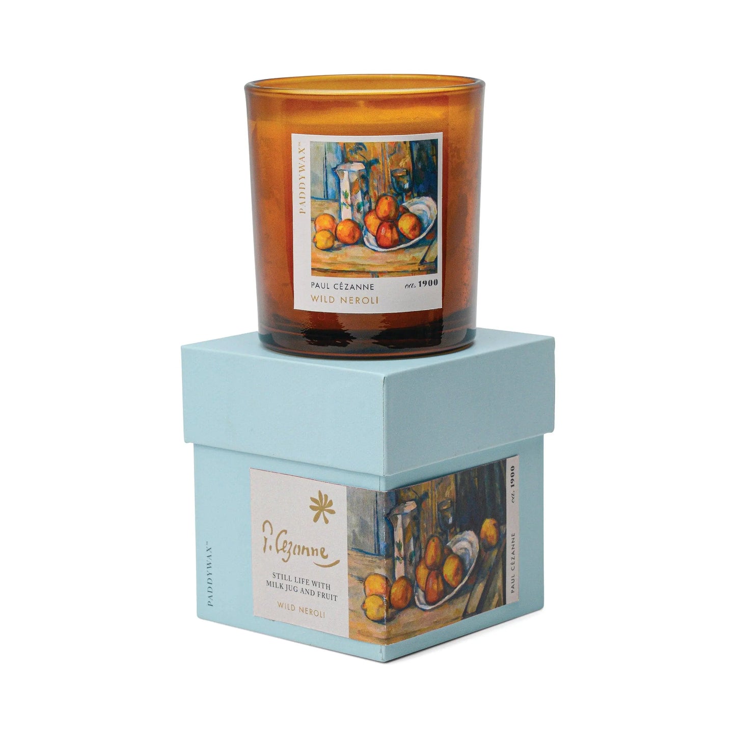 The Impressionist Candle - Cezanne Wild Neroli, in amber glass, sits on a light blue box featuring Cézanne artwork and gold text, making it part of our Impressionist art candles collection.