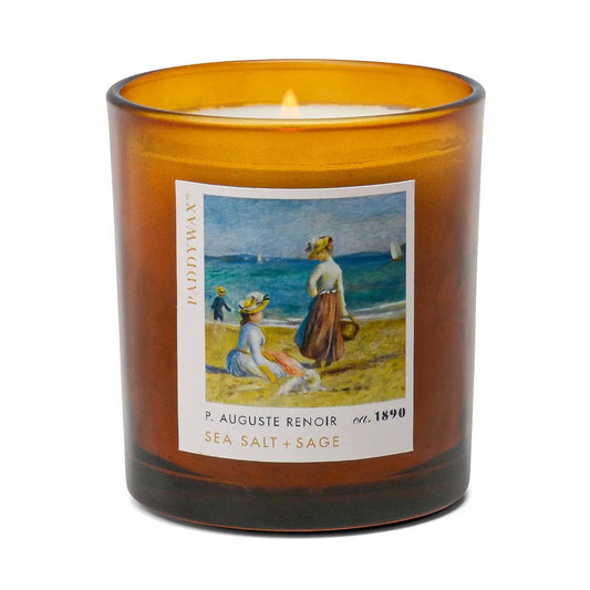 The Impressionist Candle - Renoir Sea Salt + Sage features a lit amber glass with artful fragrance, inspired by coastal charm and Renoir’s seaside artistry.