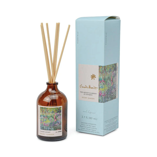 The Impressionist Diffuser - Claude Monet Secret Garden features a brown glass bottle with reeds and comes in a floral blue box inspired by Monet’s artwork.