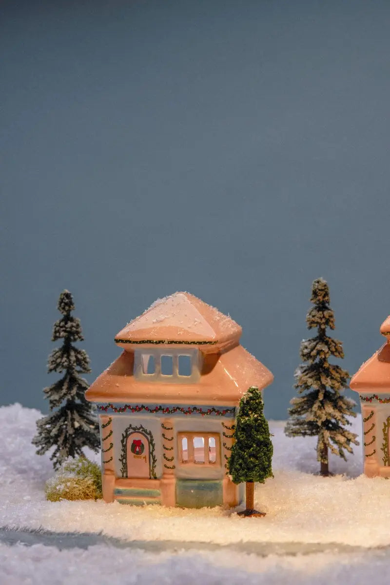 Number 06 of a Collectible Series | The East Side House is a ceramic tea light holder with lit windows, set on faux snow with mini trees and a blue backdrop—ideal for bringing East Nashville decor charm to your space.