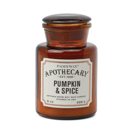 The Apothecary 8 oz Candle - Pumpkin + Spice is an artisan-made soy wax candle in a brown glass jar, poured in the USA. Enjoy cozy fall vibes with its warm vanilla bean and pumpkin spice fragrance.