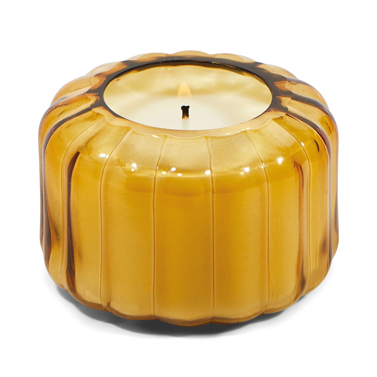 The Ripple Candle- Golden Ember glows with a lit wick in a round, ribbed amber glass container, bringing a vintage charm.