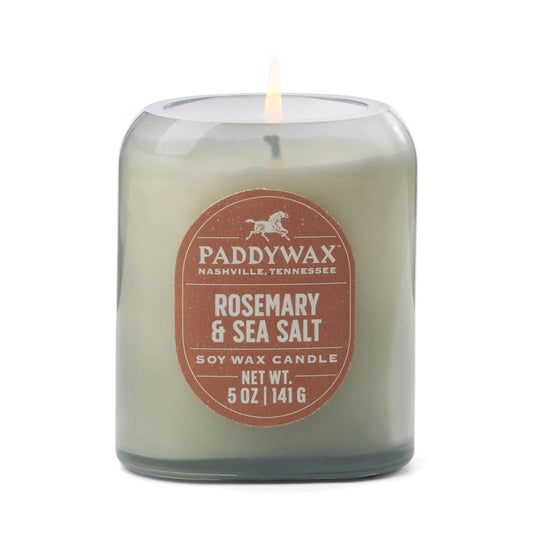 The Vista 5 oz Candle - Rosemary & Sea Salt offers a luxurious scent in a stylish glass jar with a brown label, making it the perfect accent for any modern home.