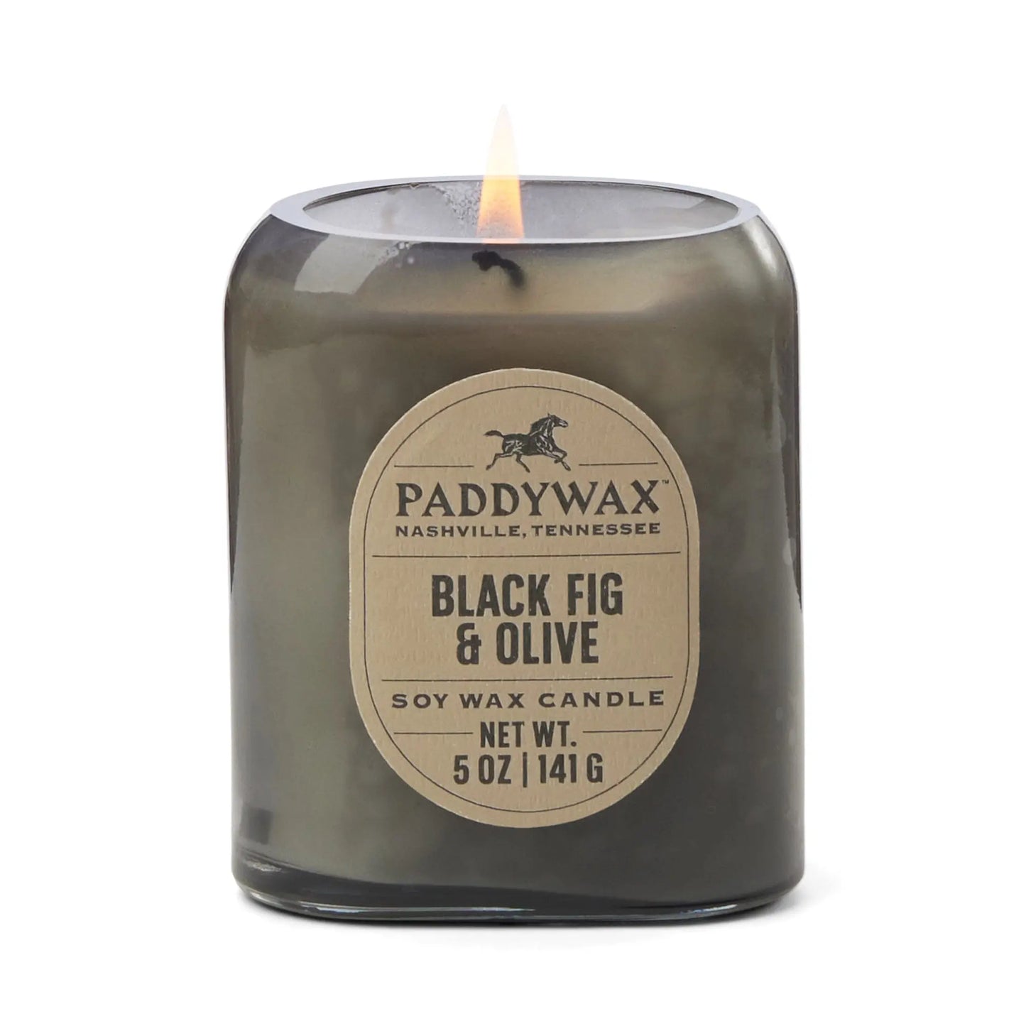 The Vista 5 oz Candle - Black Fig & Olive glows in its dark glass jar, filling your space with a luxurious scent—ideal for modern decor. The visible flame adds ambiance, while the sleek label completes the elegant look.