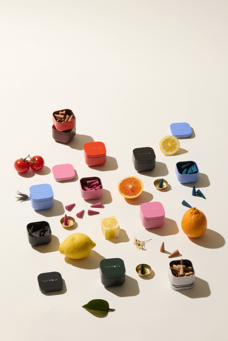 Colorful incense holders with various items on a light background