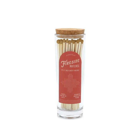 5.25" gold-tipped matches in tall glass tube with cork stopper; red label on the side reads “Fireside Matches”; 85 matches inside