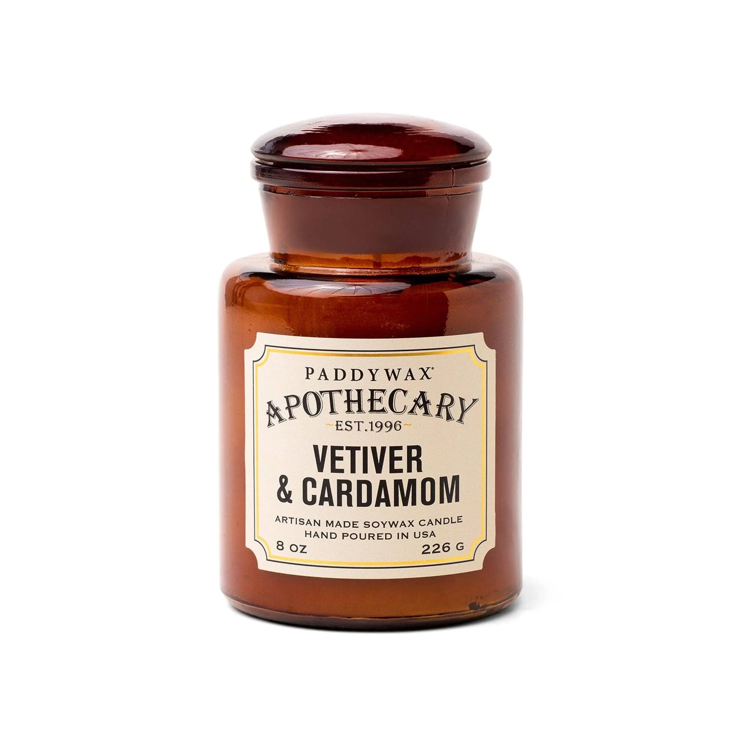 The Apothecary 8 oz Candle - Vetiver + Cardamom is an artisan soy wax candle in a vintage-style brown glass jar, offering a luxurious scent of vetiver and cardamom.