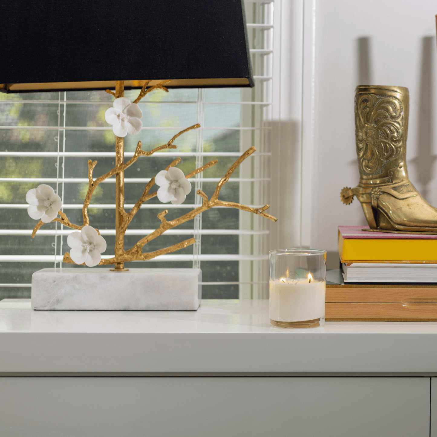 10oz Clarity two wick candle on a white table with books, home decor in front of a window