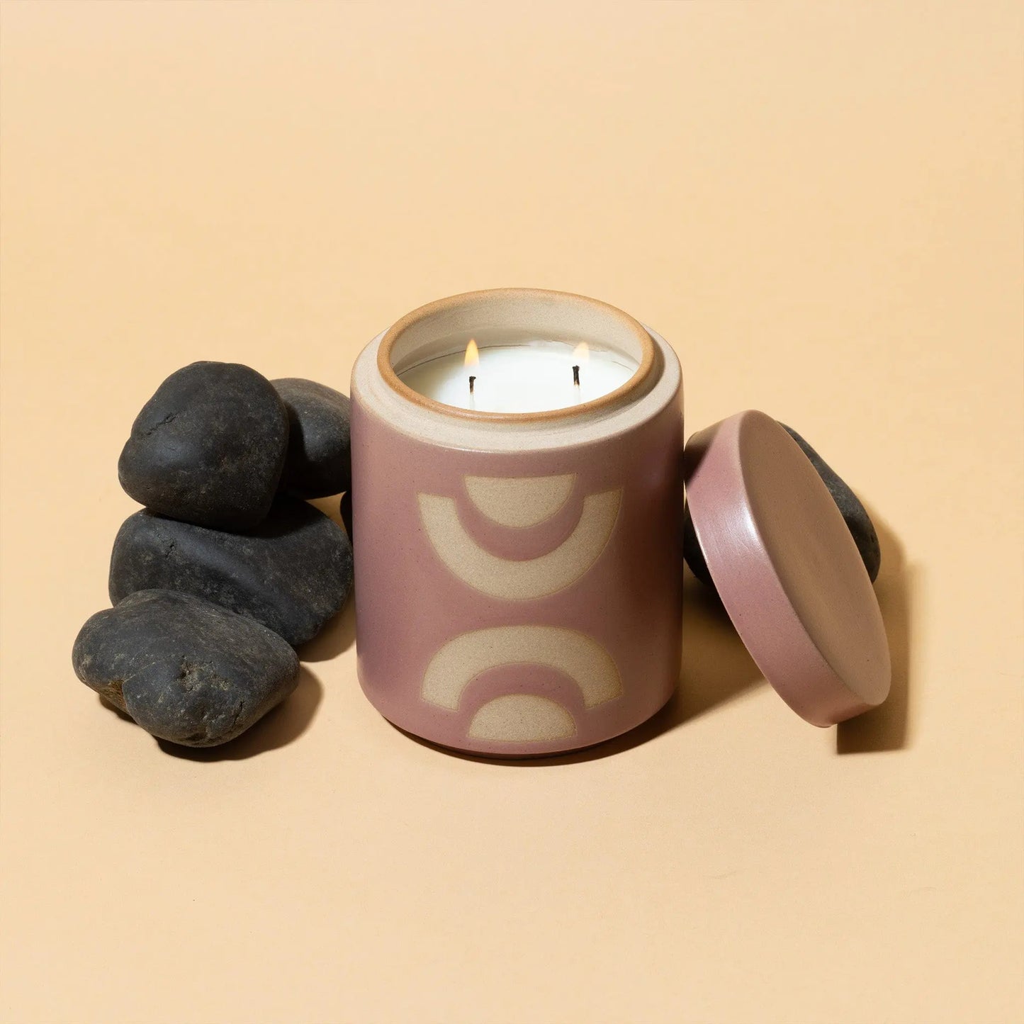 12 oz purple cylindrical ceramic vessel with ceramic lid; white wax and two cotton wicks and a beige semi-circle design on the side; pictured with lid removed