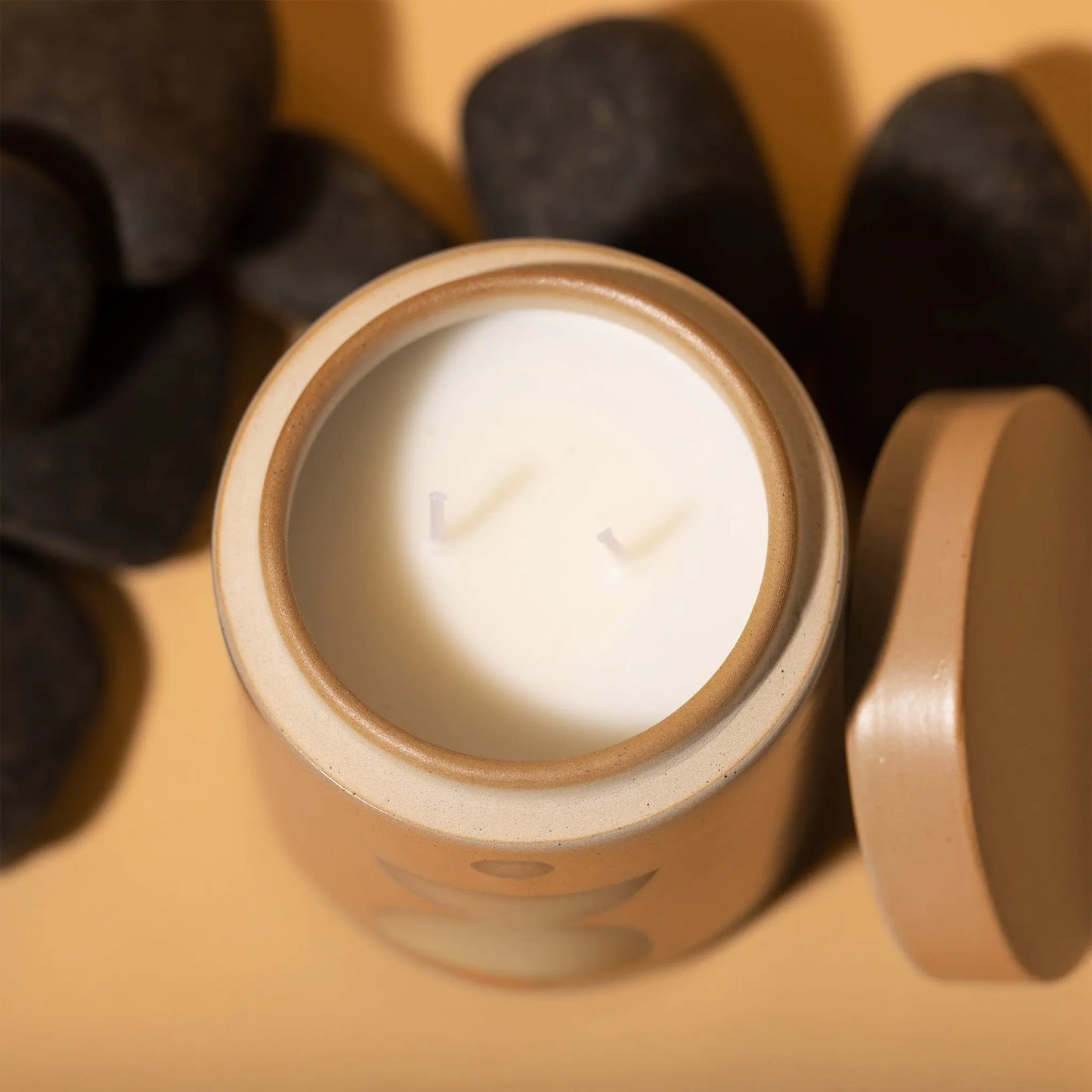 12 oz copper-colored cylindrical ceramic vessel with ceramic lid; white wax and two cotton wicks; reflected beige mirrored semi-circle design on the side