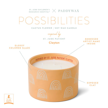 Infographic of yellow ceramic candle with product features text "St. Jude Children's Research Hospital ® x Paddywax Possibilities Cactus Flower Soy Wax Candle inspired by St. Jude Patient Clayton. Glossy colored glazed. Debossed artist name inside. Exposed clay."