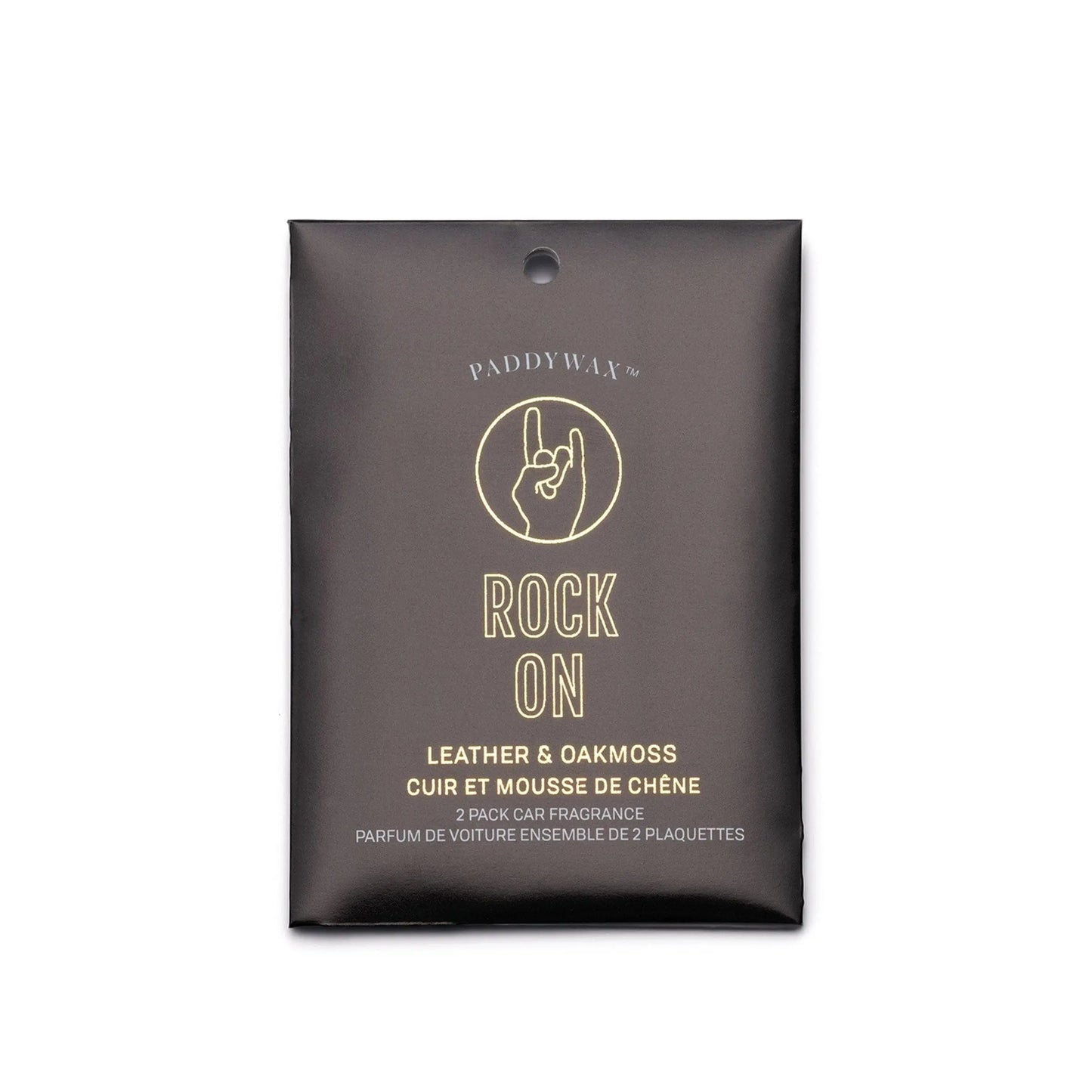 The Impressions Car Fragrance - Leather + Oakmoss Rock On features a black packet with a hand sign, offers scents of leather and oakmoss, includes an elastic for hanging, and has text in English and French.