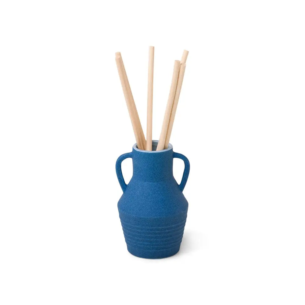 The Santorini 4 fl oz. Diffuser - Salted Blue Agave features a small blue ceramic vase with two handles and four wooden sticks, adding a stylish touch while refreshing your space with fragrance against a plain white background.