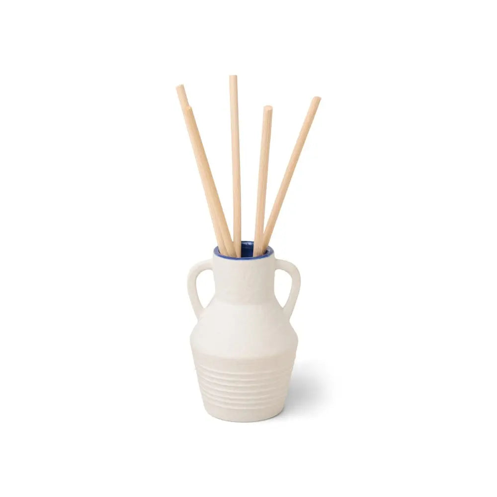 The Santorini 4 fl oz. Diffuser - Cliff & Hinoki Wood features a small white ceramic vase with two handles, holding light wooden sticks, displayed against a plain white background.