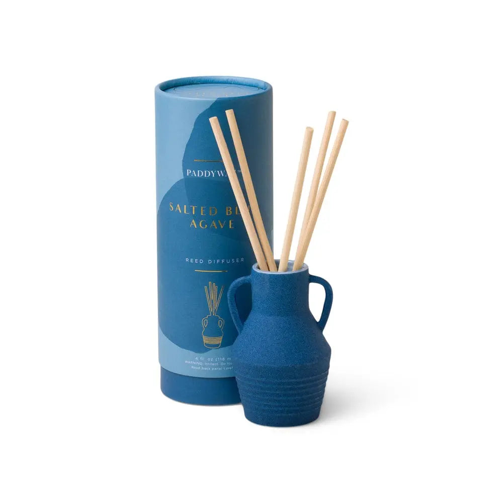 The Santorini 4 fl oz. Diffuser - Salted Blue Agave, in a blue ceramic vase with reed sticks and matching cylindrical packaging, adds a stylish fragrance refresh to any space on a white background.