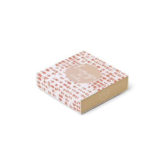 A small, square box with a beige base, pink geometric design, and Embrace the calm on the lid. Perfect for gifting with candle sets or pairing with Terrace Matches - Emerge Like Cicadas for a soothing touch.