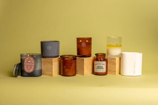Various candles from multiple candle collections arranged on a lightly colored background