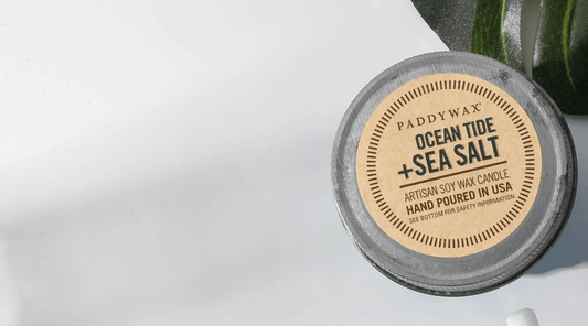 Candle Jar lid with text reading "Ocean Tide + Sea Salt; Artisan Soy Wax Candle; Hand Pouring in USA"