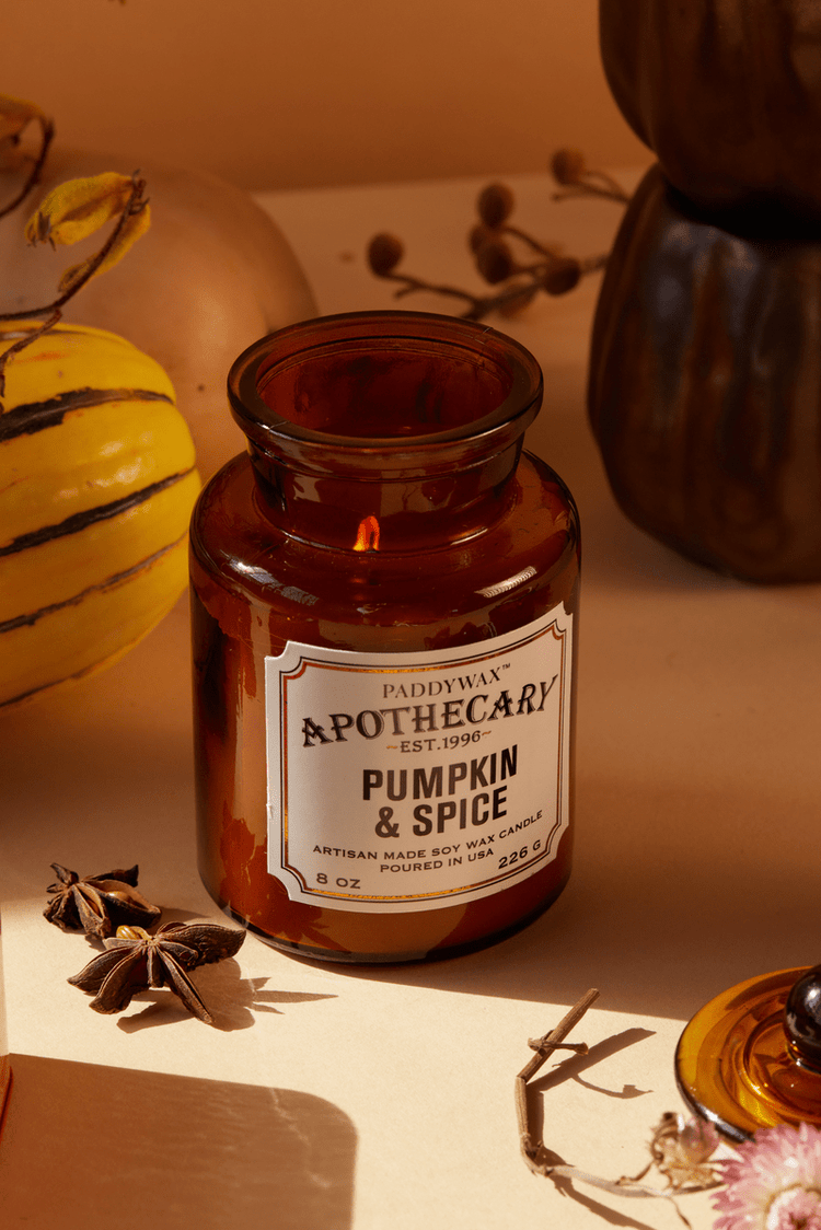 Fall candle with pumpkins on a textured table cloth