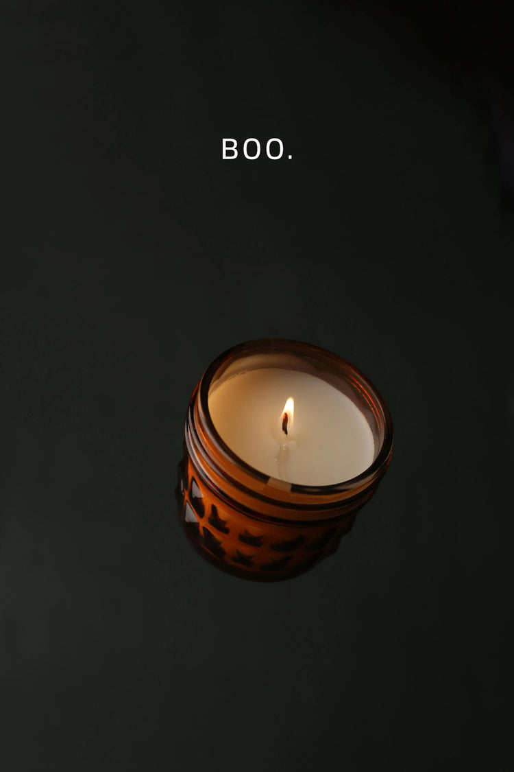 Candle in darkness with "BOO" above it