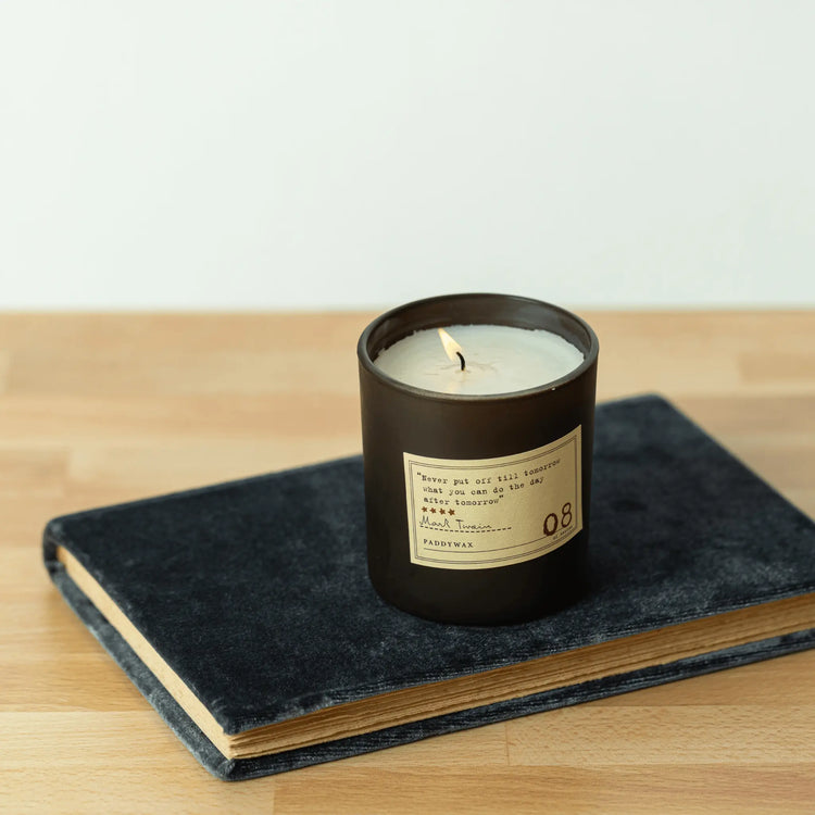 Mark Twin themed candle resting on a book 