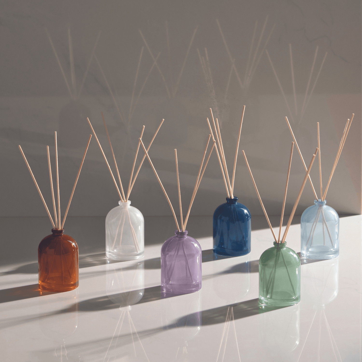Petite Reed Diffusers on marble with deep shadow