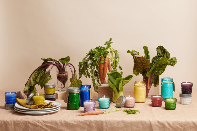 A collection of colorful candles in Mason Jar Vessels