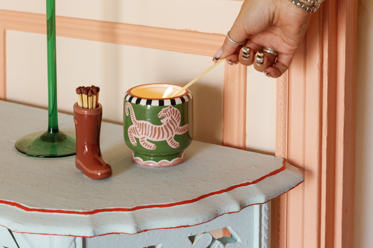 Candle surrounded by leaves and pin needles and moss