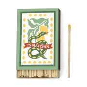 The A Dopo Snake - 75ct Boxed Matches features a green and yellow snake design on the lid, inspired by Mediterranean travels—perfect for lighting your favorite A Dopo candle.