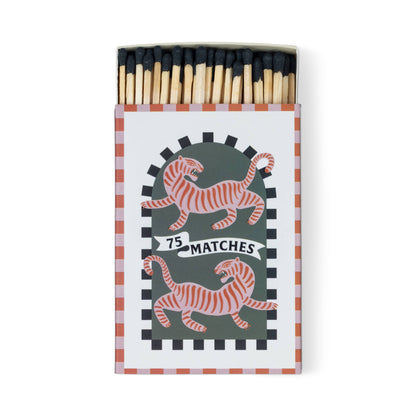 The A Dopo "Tiger" - 75ct Boxed Matches come in an open box with black-tipped matches, two orange-striped tigers facing opposite directions, and a 75 MATCHES banner on a dark green checkered background—ideal for lighting your favorite candle.