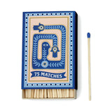 The A Dopo Eye - 75ct Boxed Matches features an elegant blue and beige design, containing 75 matches—ideal candle accessories. One match is shown separately to the box’s right.