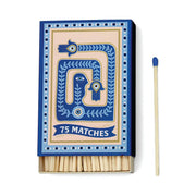 The A Dopo Eye - 75ct Boxed Matches features an elegant blue and beige design, containing 75 matches—ideal candle accessories. One match is shown separately to the box’s right.