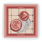 The Picnic & Pie - Peach Matches is a pink and red matchbox featuring 100 matches and an illustration of a hand holding a grapefruit half on a tiled background.